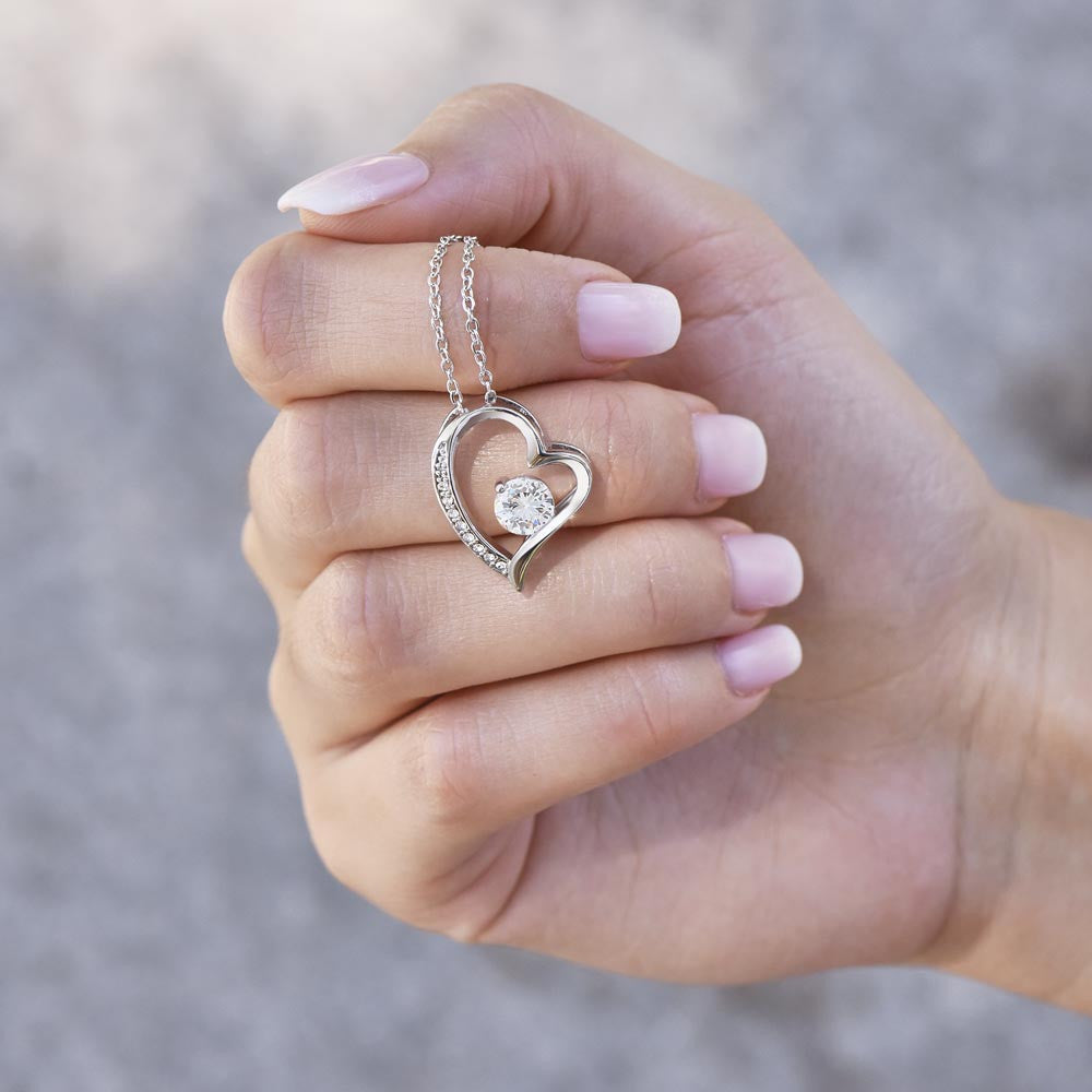 Heartbeat of My Soul - Forever Love Necklace featuring a heart-shaped 14k white gold finish pendant with cubic zirconia crystal, held in hand. Ideal romantic gift for anniversaries or Valentine's Day.